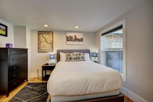 a bedroom with a large bed and a window at Little Blue Bungalow on Boise's Bench, Pet Friendly, Fully Fenced yard with doggie door! 2 miles from BSU, 5 minutes from Downtown Boise, Desk and workstation for remote workers, 2 TV's large walk-in closet, Good for mid-term stays in Boise