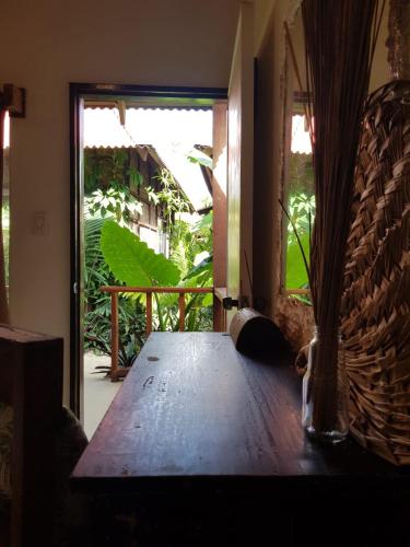 a wooden table in a room with a large window at Prana Siargao Resort in General Luna