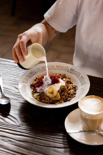 a person pouring milk into a plate of food at Prairie Hotel in Flinders Ranges