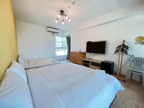 a bedroom with a white bed and a television at Cest La Vie in Eluan