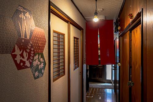 a hallway of a room with red walls and a door at Wabi Sabi Hostel in Tokyo