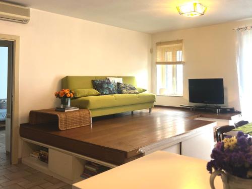 un soggiorno con divano verde e TV di Appartamento Matilde Tower House - 8 minuti a piedi dalla spiaggia a Viareggio