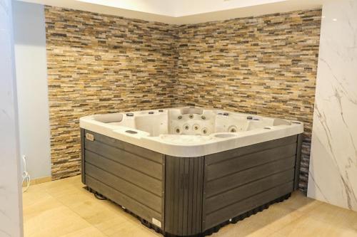 a large bath tub in a room with a brick wall at VortexLux in Kopaonik