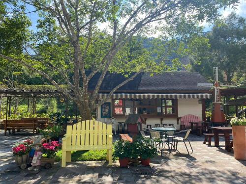 a patio with a table and chairs and a house at 南庄蔓森活Nan Juang Man Son Living in Nanzhuang