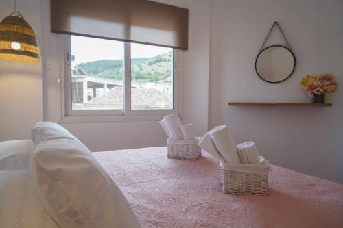 a bedroom with a bed with two chairs and a window at Jelinas bright apartment in the centre of Nafplio in Nafplio