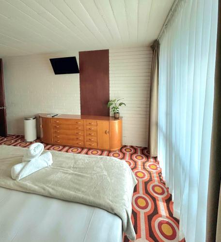 a bedroom with a bed and a dresser and a television at Indian Ocean Hotel in Perth