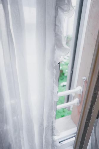 a window with a white curtain in a room at Dreierzimmer in Därligen