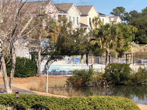 a house with a swimming pool in front of a house at 2465 Racquet Club Villa in Seabrook Island