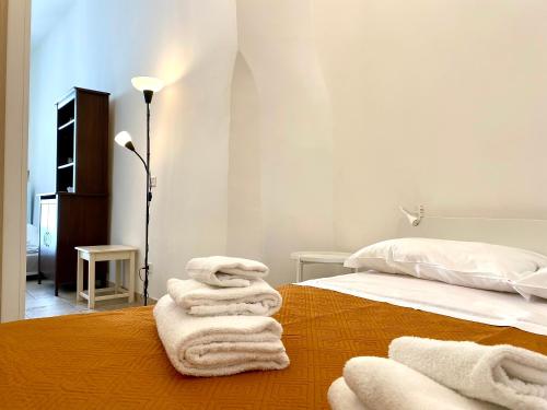 una camera da letto con asciugamani bianchi su un letto di Dimora Zia Giovanna - Puglia Mia Apartments a Monopoli