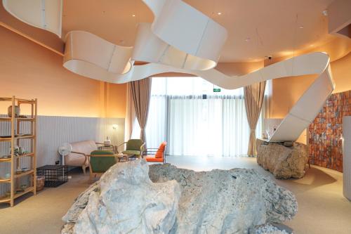 um quarto com uma cama grande e um lustre grande em YAN YU JIAN Art Hotel em Zhangjiajie