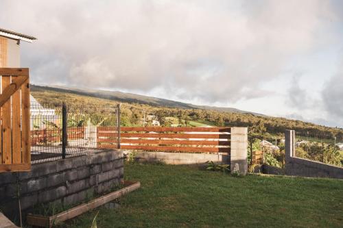 a fence in a yard with a hill in the background at La Kaz en lèr - Calme et Vue - idéal Randos in Le Tampon