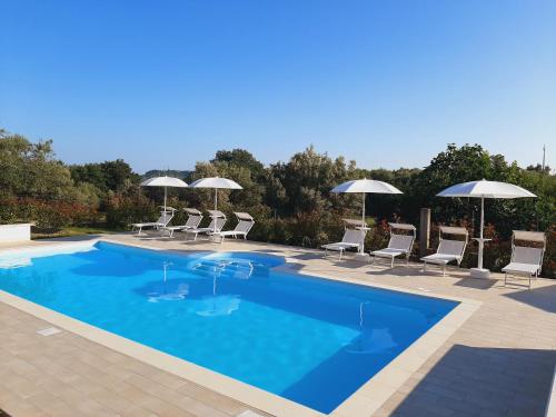 a swimming pool with chairs and umbrellas at Agriturismo Il Casolare Di Nonno Mario in Manoppello