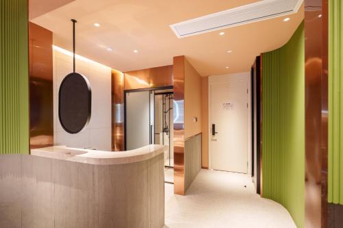 a hallway with green walls and a bathroom with a sink at YAN YU JIAN Art Hotel in Zhangjiajie