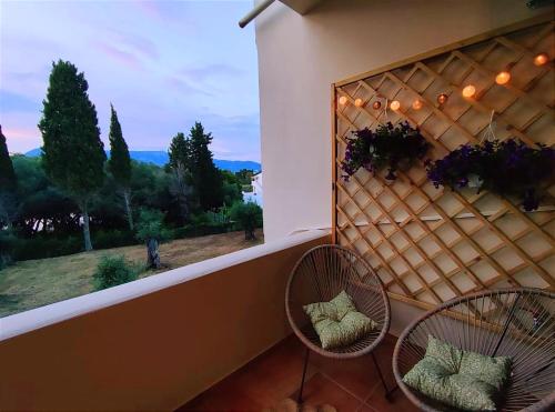 a balcony with two chairs and a window with a view at Coritos apartments 2 Corfu in Kontokali