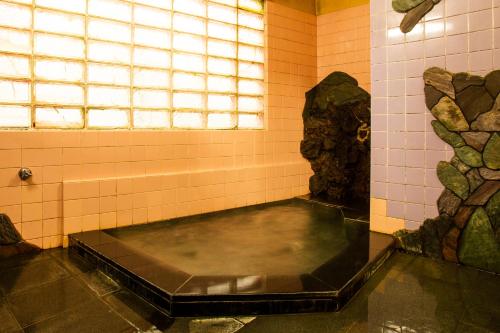 a bath room with a pool of water and a window at Yoshiharu in Toyooka