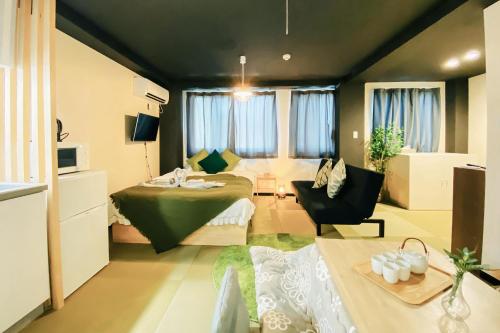 a bedroom with a bed and a room with a couch at Tokyo Asakusa New Condo Sensoji-6min in Tokyo