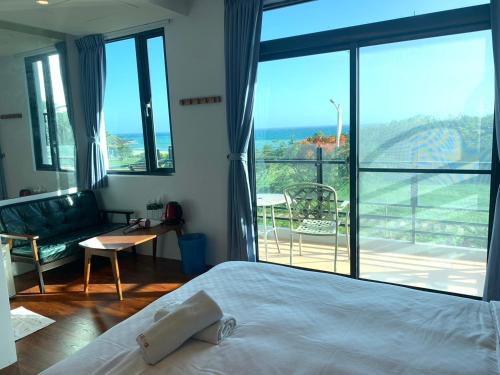 a bedroom with a bed and a large window at Happiness Inn in Kenting