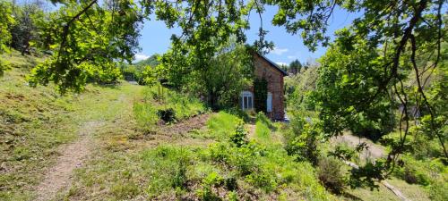 an old brick house in the middle of a field at Gîte familial de la Bastide du puech in Cransac