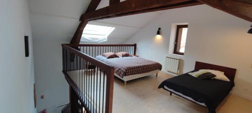 - une chambre mansardée avec un lit et une fenêtre dans l'établissement Gîte familial de la Bastide du puech, à Cransac