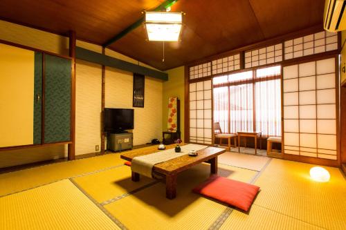 a living room with a wooden table in a room at Yoshiharu in Toyooka