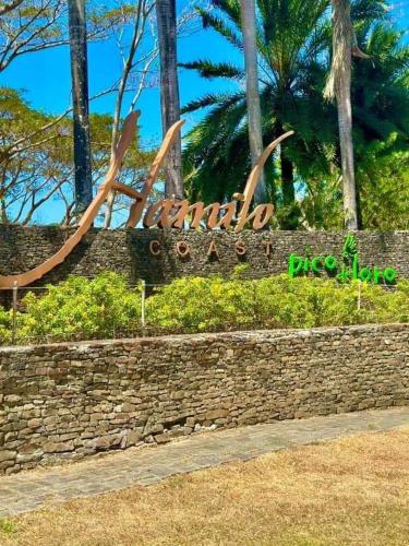 ein Schild für ein Hotel an einer Steinmauer in der Unterkunft Pico De Loro Room Rental in Nasugbu