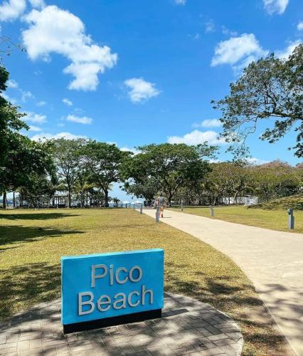 Pico De Loro Room Rental في ناسوغبو: علامة لشاطئ البيتزا في الحديقة