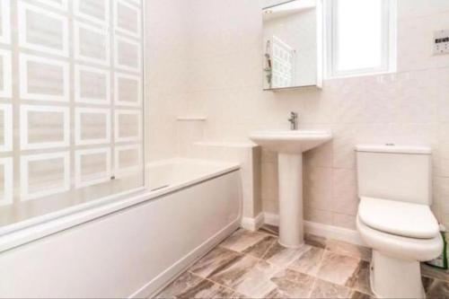 a bathroom with a toilet and a sink and a tub at Nice house + Car parking + Close to the city centre in Manchester