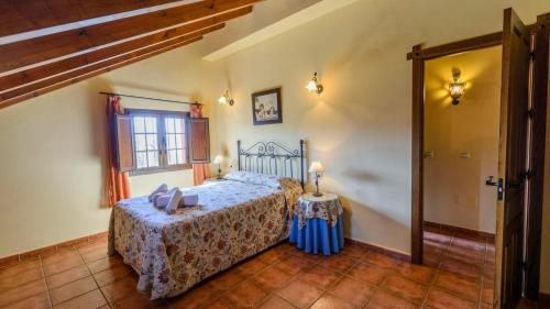 Schlafzimmer mit einem Bett, einem Tisch und einem Fenster in der Unterkunft Casa Loma el Letrao Almogia by Ruralidays in Almogía