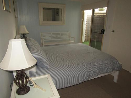 a bedroom with a bed and a lamp on a table at St Helens Beachfront - Absolute Beachfront in Edithburgh