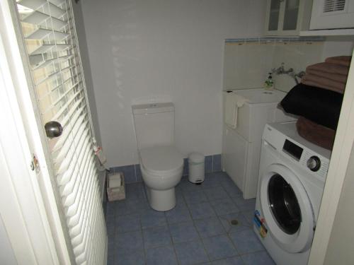 a bathroom with a toilet and a washing machine at St Helens Beachfront - Absolute Beachfront in Edithburgh