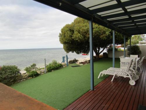 a deck with two white chairs and a view of the ocean at St Helens Beachfront - Absolute Beachfront in Edithburgh