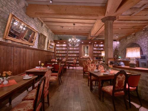 un ristorante con tavoli e sedie in biblioteca di Historik Hotel Gotisches Haus garni a Rothenburg ob der Tauber