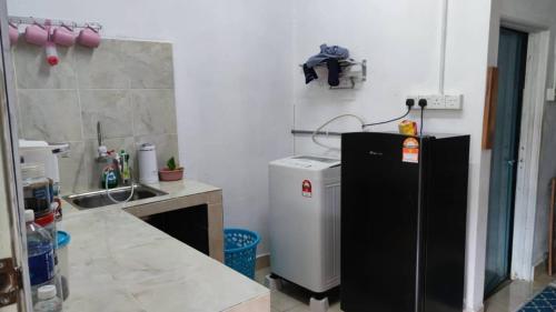 una cucina con frigorifero e lavandino di Teratak Malaika a Huma