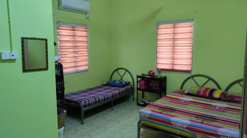 una camera con due letti e due finestre di Teratak Malaika a Huma
