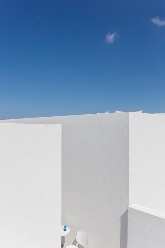 a room with two chairs and a blue sky at Neo Suites in Fira