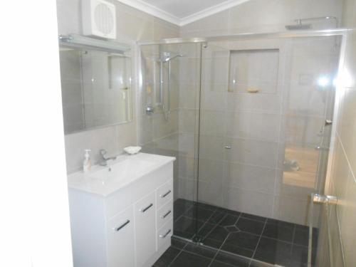 La salle de bains est pourvue d'un lavabo et d'une douche. dans l'établissement Blue Line Retreat - Unit 1, à Port Vincent