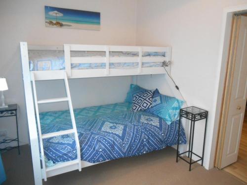 - une chambre avec des lits superposés et une couette bleue dans l'établissement Blue Line Retreat - Unit 1, à Port Vincent