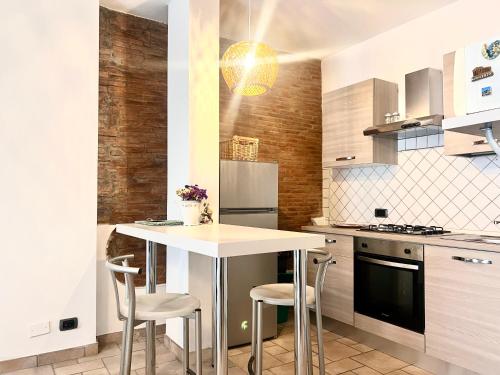 una cucina con tavolo e sgabelli di Appartamento Matilde Tower House - 8 minuti a piedi dalla spiaggia a Viareggio