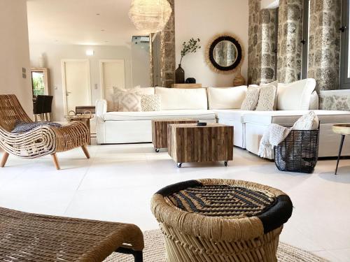 a living room with a white couch and chairs at Villa Tartaya in Dassia