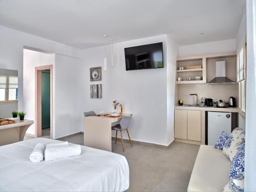 Habitación blanca con cama y cocina en Bedspot Apartments Paros, en Naousa