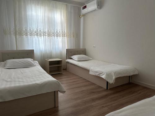 a room with two beds and a window at GUESTO HOSTEL in Tashkent
