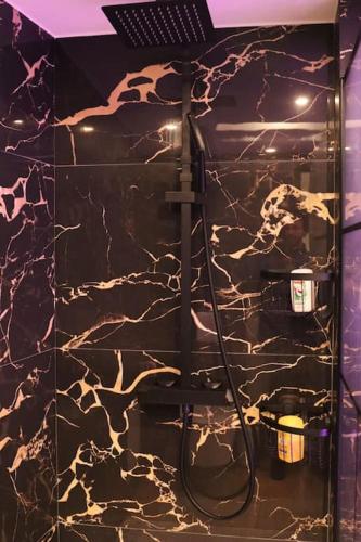 La salle de bains est pourvue d'un mur en marbre noir et blanc. dans l'établissement Pavillon en loft 87 M 10e, jacuzzi, à Marseille