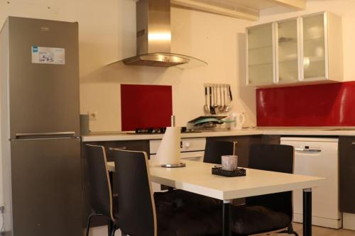 eine Küche mit einem Tisch mit Stühlen und einem Kühlschrank in der Unterkunft Pavillon en loft 87 M 10e, jacuzzi in Marseille