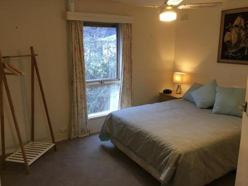 a bedroom with a large bed and a window at Eagles Nest - Ardrossan in Ardrossan