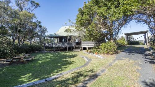 a house with a picnic table in the yard at The Point Ultimate Beach House in Yamba