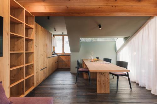 una sala da pranzo con tavolo e sedie in legno di Max Green Forest Apartments a Siusi