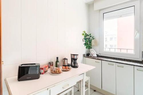 una cucina bianca con bancone e forno a microonde di Apartamento Centro de Santander a Santander