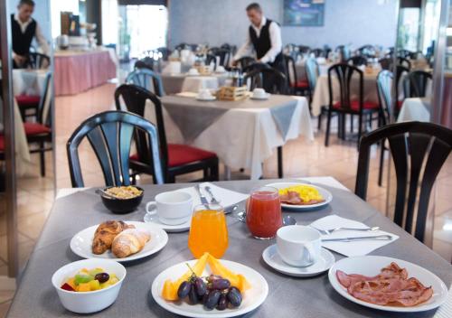 a table with plates of breakfast food on it at SunLake Hotel in Riva del Garda