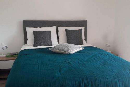 - un lit avec une couverture bleue et des oreillers dans l'établissement Très joli appartement T3 fraîchement rénové, dans résidence hôtellière, à Lecci