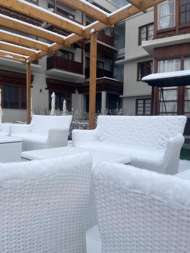 a row of white wicker chairs sitting under a pergola at Ashoka Ladakh in Leh